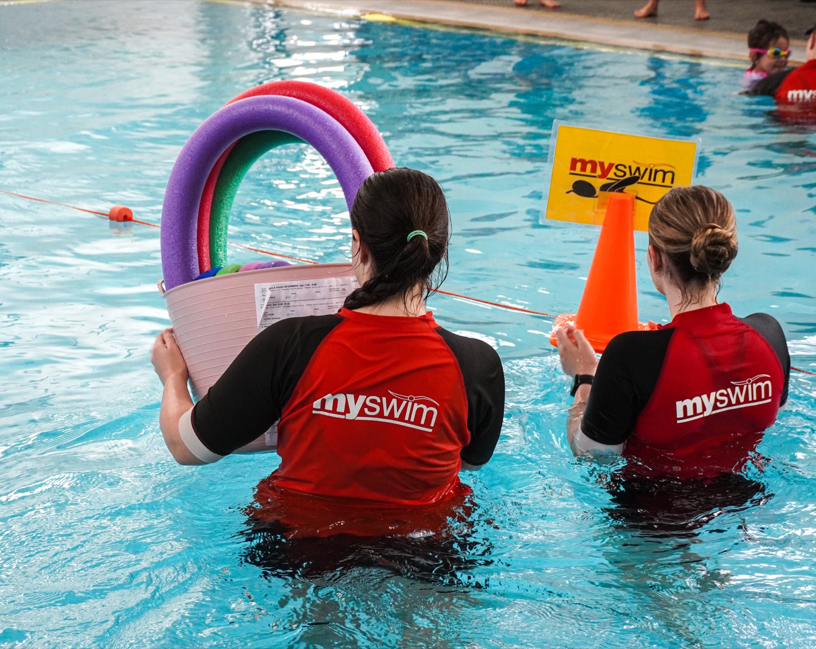 Two Myswim instructors in the pool with teaching toys